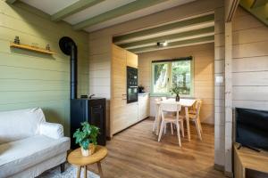 una sala de estar con un sofá y una mesa en ArdenParks PetiteSuisse Chalet Renardeau, en Manhay