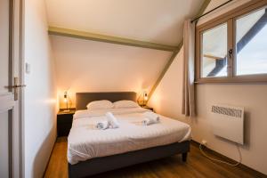 Un dormitorio con una cama y una ventana en ArdenParks PetiteSuisse Chalet Renardeau, en Manhay 19 fotos más