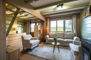una sala de estar con un sofá y dos sillas en ArdenParks PetiteSuisse Chalet Renardeau, en Manhay