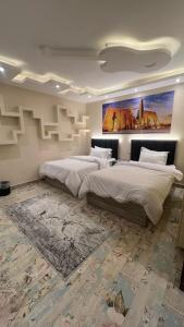 a bedroom with two beds and a painting on the wall at شقه فندقية على النيل in Al Ma‘şarah +13 photos