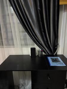 een zwarte ladekast met een raam met een zwart gordijn bij Private Studio Apartment in Lagos +9 foto's