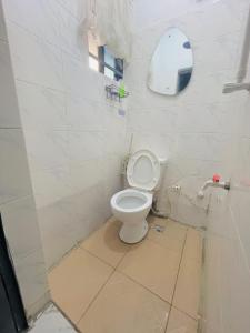 een witte badkamer met een toilet en een spiegel bij Private Studio Apartment in Lagos