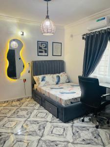 een slaapkamer met een bed, een bureau en een stoel bij Private Studio Apartment in Lagos