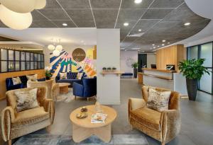a waiting room with chairs and a table at Citadines Barbican London in London