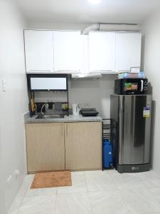 una cocina con fregadero y refrigerador en SKL Staycation Hub, en Mandaue