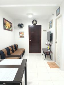 Una sala de estar con un sofá y un televisor en SKL Staycation Hub, en Mandaue