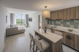a kitchen and living room with a table and chairs at Hyatt Place Cancun Airport in Cancún