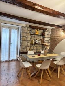 a dining room with a stone wall and a table and chairs at Deattellis House accogliente mansarda in palazzo storico in Campobasso
