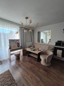 una sala de estar con un sofá y una mesa en Apartament Leśny Zakątek, en Reda