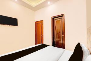 a bedroom with a bed and a tv on the wall at The Krishna's Bliss in Ghaziabad