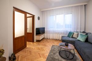 un soggiorno con un divano e una televisione di NDK Garden at Vitosha Blvd Absolutely Top Center with Free Parking a Sofia