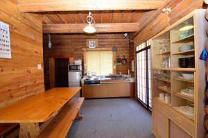 a kitchen with wooden walls and a wooden table at Hakuba Haven Lodge in Hakuba