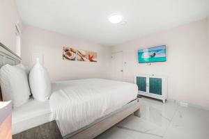 ein weißes Schlafzimmer mit einem Bett und einem Fenster in der Unterkunft Monserat 33Q in Palm-Eagle Beach