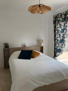 BuzignarguesにあるMaison Nichée Au Cœur Des Pinsの大きな白いベッドと枕が2つある寝室