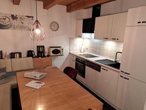 a kitchen with a wooden table in a kitchen at Ferienhaus Walter im Waldferiendorf in Regen