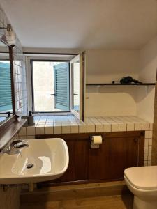 a bathroom with a sink and a toilet and a window at Deattellis House accogliente mansarda in palazzo storico in Campobasso +24 photos