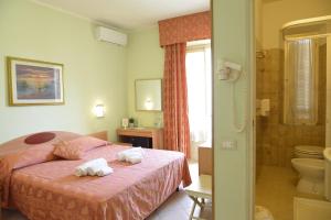 een hotelkamer met een bed en een badkamer bij Hotel Massimo in Viareggio +64 foto's
