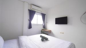 a bedroom with a bed with a television on the wall at JS Sentul City Syariah in Cibitung