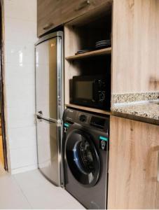 uma cozinha com máquina de lavar e micro-ondas em Homecoming maitama em Abuja