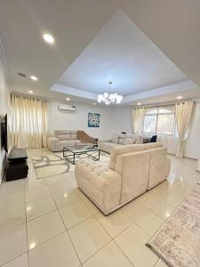 uma grande sala de estar com sofás e uma TV em Homecoming maitama em Abuja