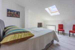 ein Schlafzimmer mit einem Bett und zwei roten Stühlen in der Unterkunft Apartments Sunshine D in Crikvenica