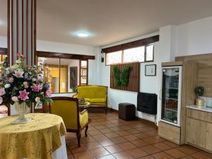 Una sala de estar con una mesa con un jarrón de flores. en Hotel Cacique Real, en Zipaquirá
