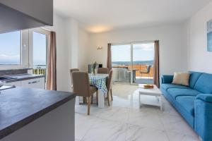 ein Wohnzimmer mit einem blauen Sofa und einem Tisch in der Unterkunft Apartments Sunshine D in Crikvenica