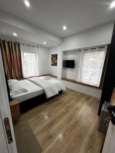 a bedroom with a bed and a flat screen tv at Luz de Sol Rooms in Krujë