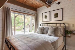 ein Schlafzimmer mit einem Bett und einer Glasschiebetür in der Unterkunft Acorn Falls, Bass Lake, Ca in Bass Lake