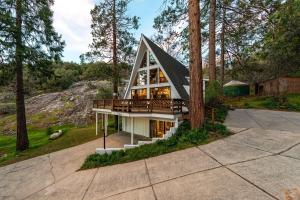 ein Haus im Wald mit schwarzem Dach in der Unterkunft Acorn Falls, Bass Lake, Ca in Bass Lake