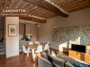 a dining room with a table and white chairs at Canovetta Country Houses - nearby Cremona in Dosimo