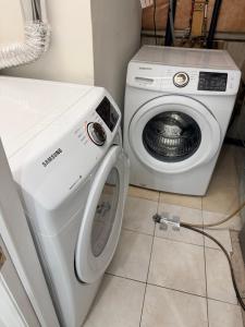 a washer and dryer sitting next to a washing machine at Modern Cozy Basement Suite Free Parking in Brampton