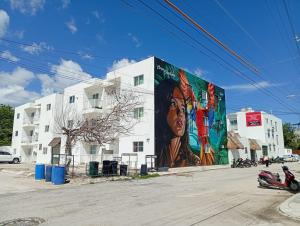 a building with a large mural on the side of it at Deptos Alma in Tulum
