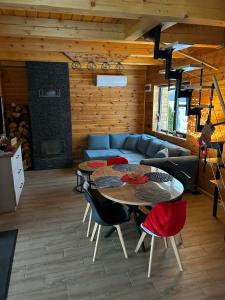 ein Wohnzimmer mit einer Couch und einem Tisch und Stühlen in der Unterkunft Domek w Budzie Ruskiej in Buda Ruska