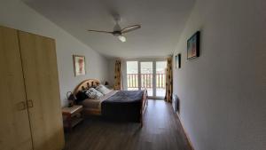 a bedroom with a bed and a ceiling fan at Gites Le Grand Jardin in Puydarrieux
