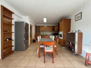 a kitchen with a table and chairs and a refrigerator at Casa dos Cabecinhos in Oliveira do Hospital +22 photos