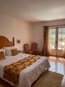 Un dormitorio con una cama y dos sillas y una ventana. en Hotel Quinta Da Lagoa, en Praia de Mira