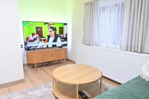 een woonkamer met een flatscreen-tv en een tafel bij Villa Natalia in Kremen