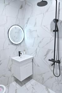 een witte badkamer met een wastafel en een spiegel bij Villa Natalia in Kremen