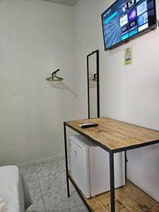 a room with a table and a tv on the wall at Suite Campina - Business Hotel in Campina do Monte Alegre