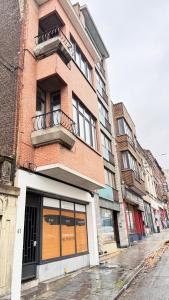 a brick building with a balcony on a city street at Orléan 41 A centre-gare-aéroport in Charleroi +6 photos