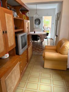 ein Wohnzimmer mit Sofa und Fernseher in der Unterkunft Cute house  + 7 Fotos