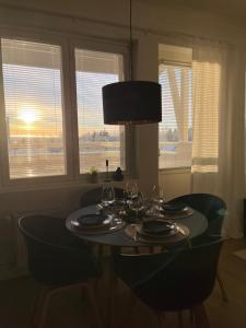 tavolo da pranzo con bicchieri da vino e lampada di Keisari Apartment a Rovaniemi