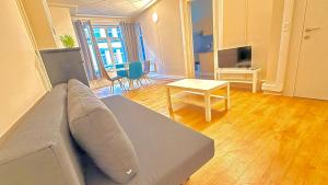 a living room with a couch and a table at Orléan 41 B centre-gare-aéroport in Charleroi