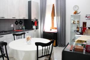 LaurenzanaAgriBnB Casa Furnaredda的厨房配有白色的桌椅