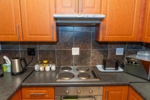 una cucina con mobili in legno e un forno a piano cottura di Geluk Cottage a Somerset East