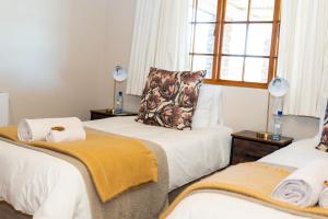 una stanza con due letti e una finestra di Geluk Cottage a Somerset East