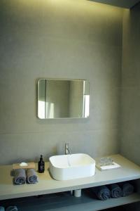 ein Badezimmer mit Waschbecken und Spiegel in der Unterkunft Greywood in Gili Trawangan + 5 Fotos