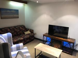 a living room with a couch and a flat screen tv at Hôtel particulier du marché in Quebec City