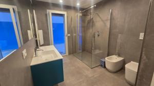 a bathroom with a sink and a shower and a toilet at Villa Mar y Luna in Lignano Sabbiadoro